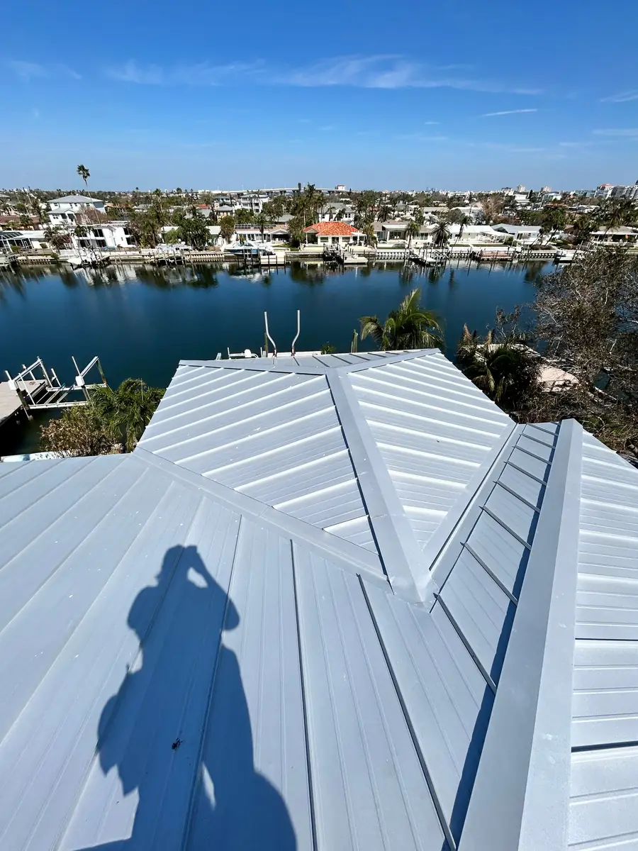 Metal roof inspection on a Gulf Coast waterfront home after a hurricane